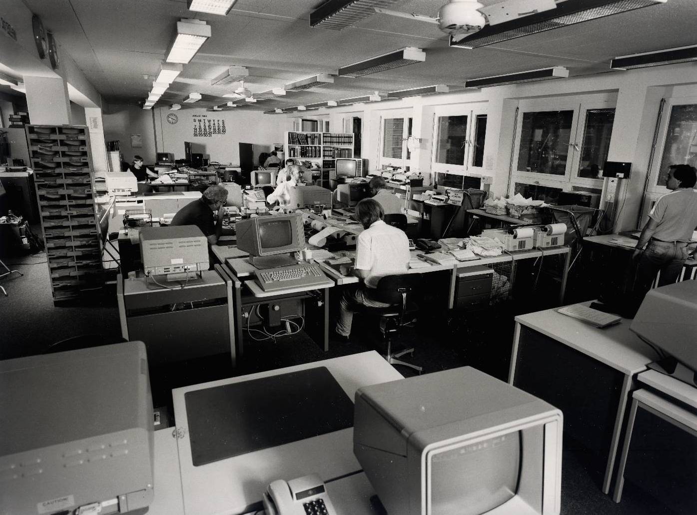 MUNICH -- An overall view of the Central News Room at Radio Free Europe/Radio Liberty. Central News is an internal news agency serving as clients the news desks of the 21 different language services within the radio. The news room takes in more than a million-and-a-half words every 24 hours from Western and Eastern news agencies, its own bureaus in major capitals of the world, Eastern radio and television. Editors boil this huge flow down into a running file of just over 100,000 words daily that move out to the 21 news desks on two in-house wires around the clock.